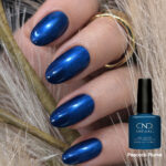 Vernis semi-permanent CND Shellac Peacock Plume bleu profond irisé appliqué sur ongles avec finition brillante