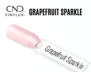 Capsule du vernis CND™ VINYLUX™ Grapefruit Sparkle, un rose clair scintillant semi-opaque au fini nacré brillant, avec des micro-paillettes fines reflétant la lumière.