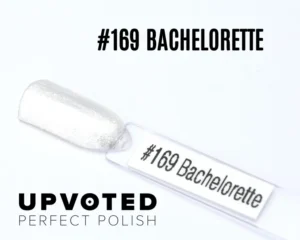 Capsule du vernis semi-permanent NailPerfect Upvoted #169 Bachelorette, un blanc argenté scintillant et élégant.