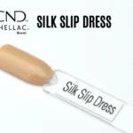 Le visuel montre la capsule du vernis CND™ Shellac Silk Slip Dress, beige doré lumineux et soyeux, à la finition crème homogène.