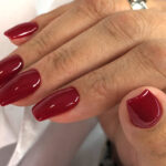 Vernis semi-permanent CND Shellac Tinted Love rouge profond appliqué sur ongles, finition brillante et élégante