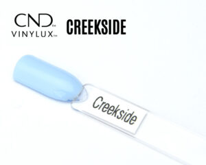 Capsule de présentation du vernis CND™ VINYLUX™ Creekside, un bleu ciel pastel opaque au fini crème brillant, illustrant fidèlement la teinte douce et lumineuse du vernis longue tenue.