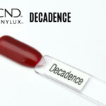 Capsule de présentation du vernis CND™ VINYLUX™ Decadence, un rouge rubis profond opaque au fini crème brillant, montrant fidèlement la couleur luxueuse du vernis longue tenue.