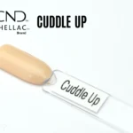 Le visuel montre la capsule du vernis CND™ Shellac Cuddle Up, beige nude chaud et brillant à la finition naturelle.