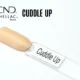 Le visuel montre la capsule du vernis CND™ Shellac Cuddle Up, beige nude chaud et brillant à la finition naturelle.