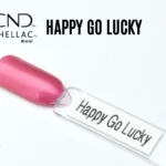 Le visuel montre la capsule du vernis CND™ Shellac Happy Go Lucky, rose vif irisé brillant et lumineux à la finition nacrée.