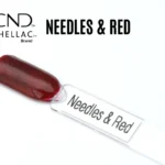 Capsule du vernis semi-permanent professionnel CND™ Shellac Needles & Red, rouge translucide profond agrémenté de fines paillettes sombres pour un rendu scintillant et élégant.