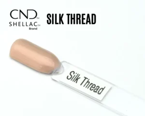 Le visuel montre la capsule du vernis CND™ Shellac Silk Thread, beige rosé irisé au fini soyeux et lumineux.