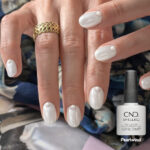Vernis semi-permanent CND Shellac Pearlwind blanc nacré irisé avec nail art perles sur ongles brillants