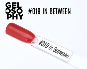 Capsule du vernis semi-permanent AstonishingNails Gelosophy #019 In Between, un corail rosé lumineux et brillant.