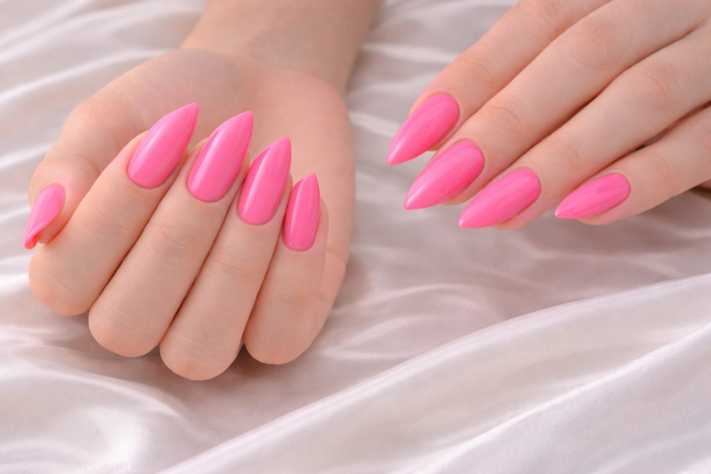 Deux mains avec ongles en forme lipstick et vernis rose vif brillant